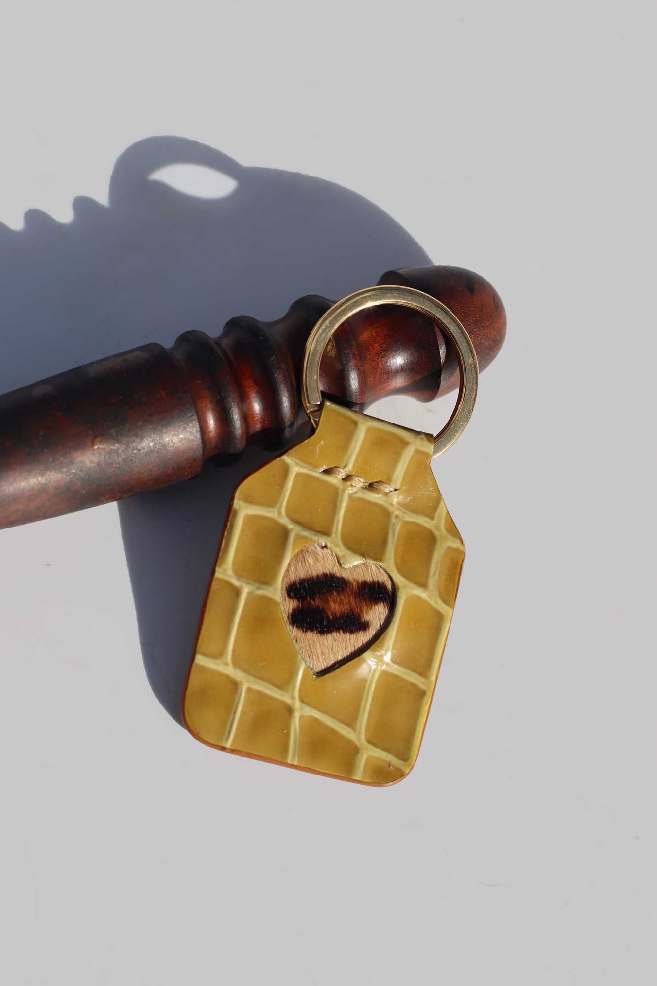 Kaki keychain with a heart design on a gray background