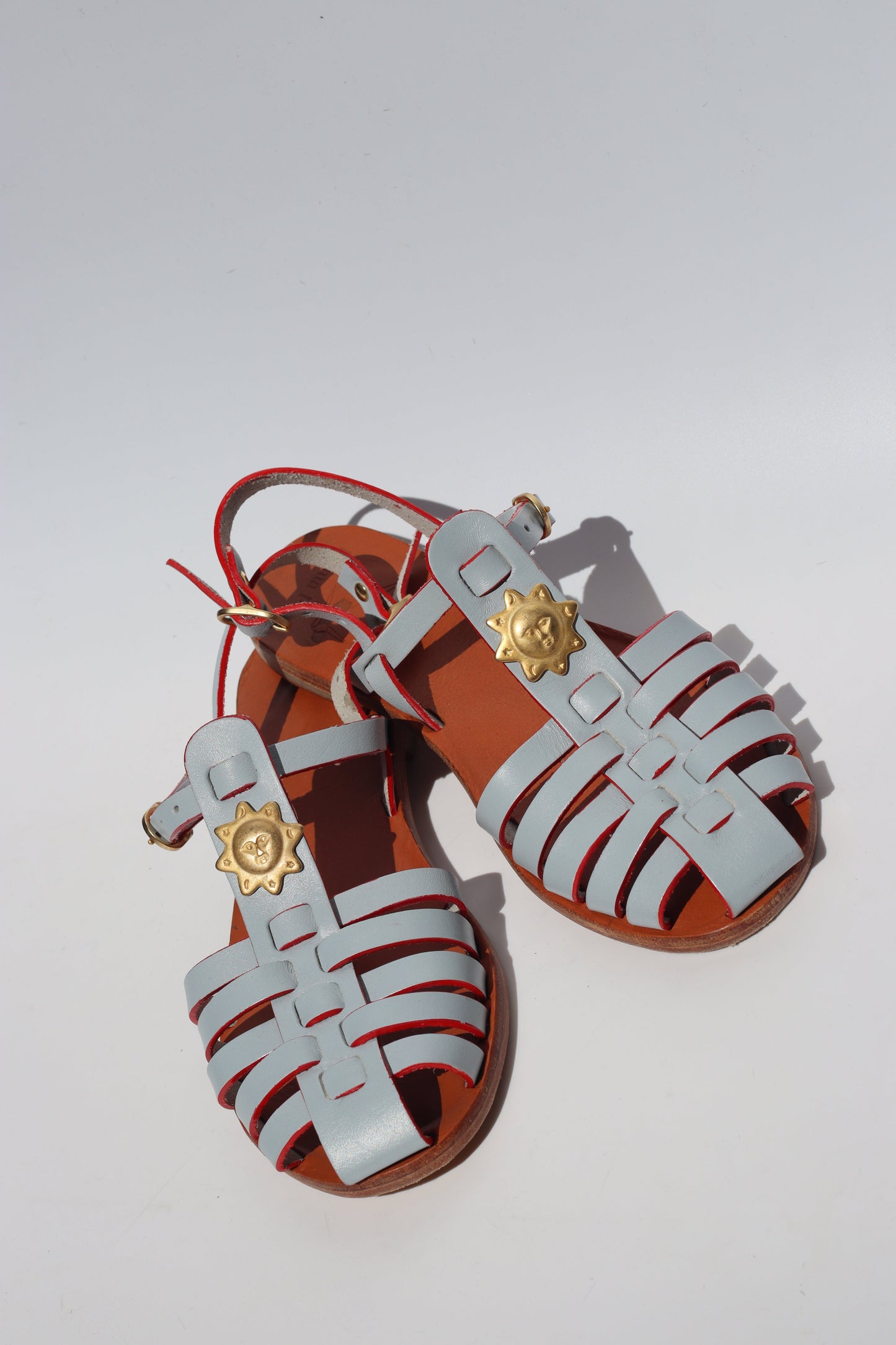 Light blue leather fisherman sandals with gold sun charm, women's flat caged toe sandals Lisbon