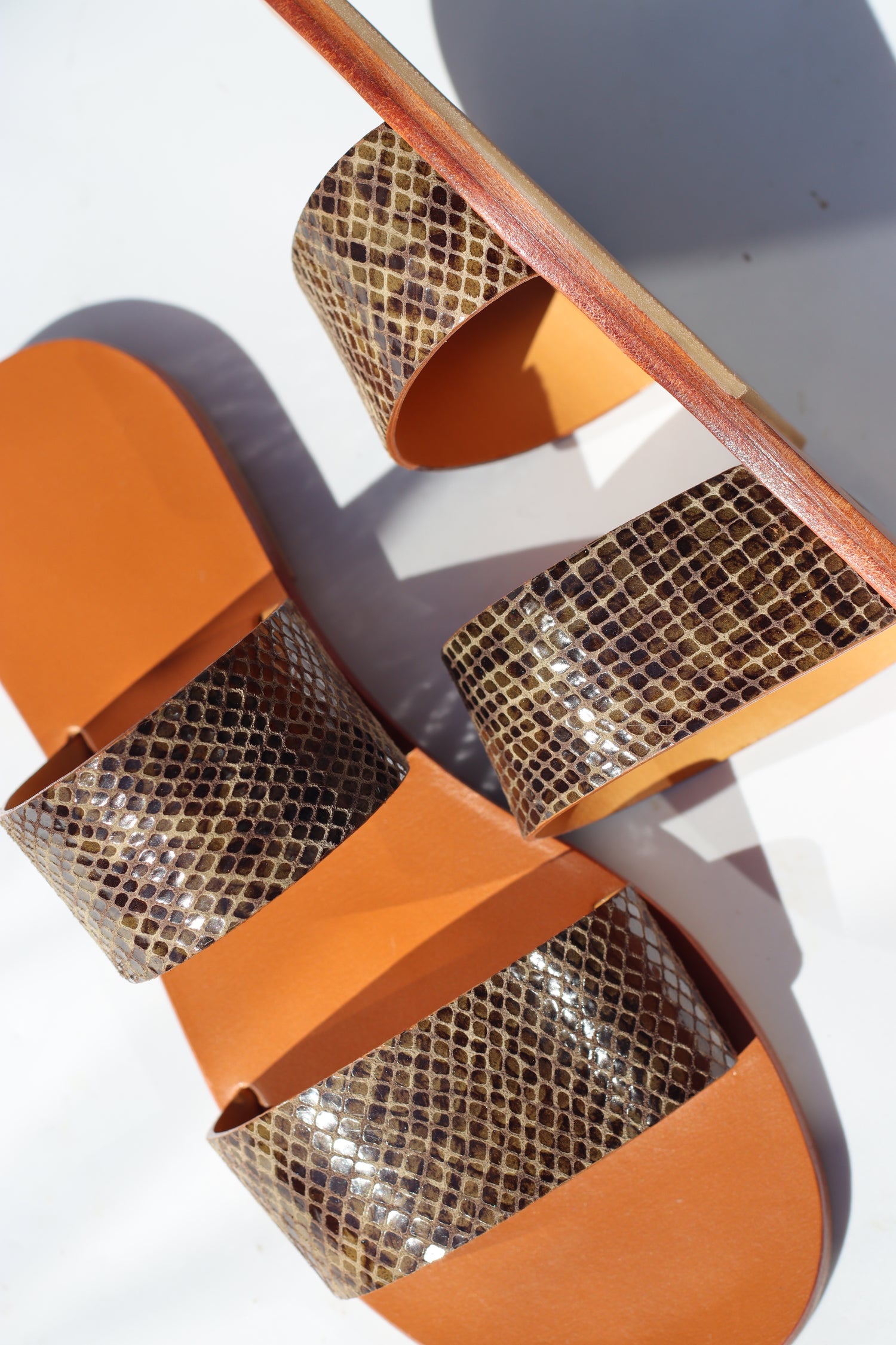 Pair of sandals with kaki straps and mesh design on a white background