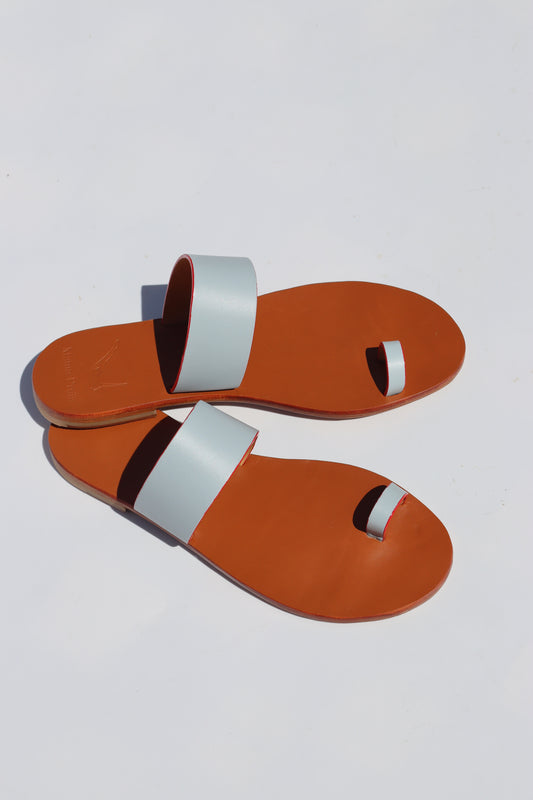 Pair of camel sandals with light blue straps on a white background