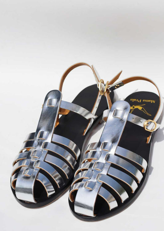 Pair of metallic sandals with a brand logo on a light gray background