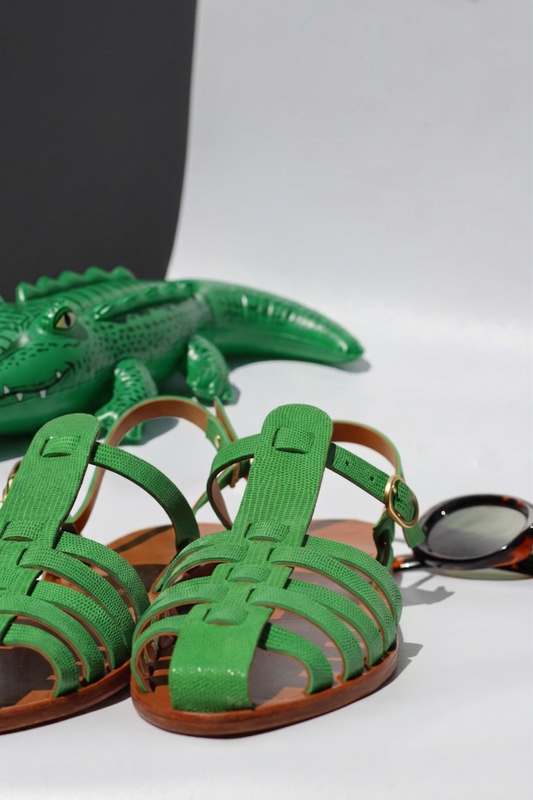 Green sandals with brown soles on a white background