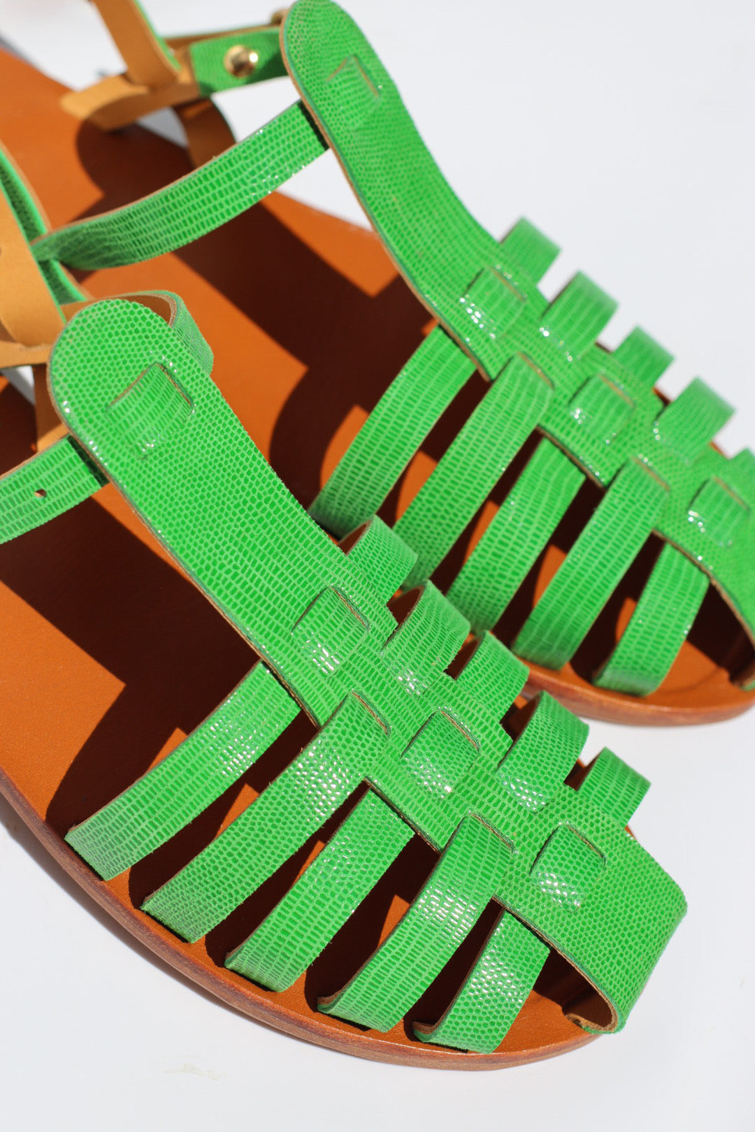 Green sandals with brown soles on a white background