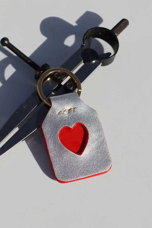 Keychain with red heart design on a light gray background