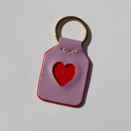 Purple keychain with a red heart on a light gray background