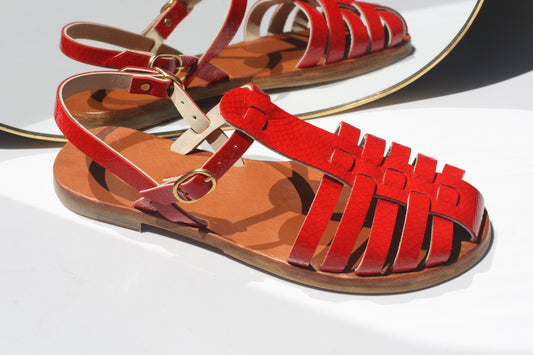 Red glossy leather flat sandals with caged toe and ankle strap, inner lining in camel leather.